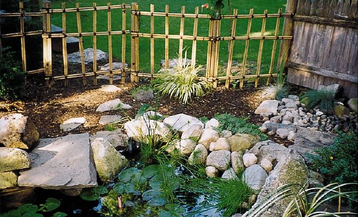 hand-built bamboo fence behind a water garden