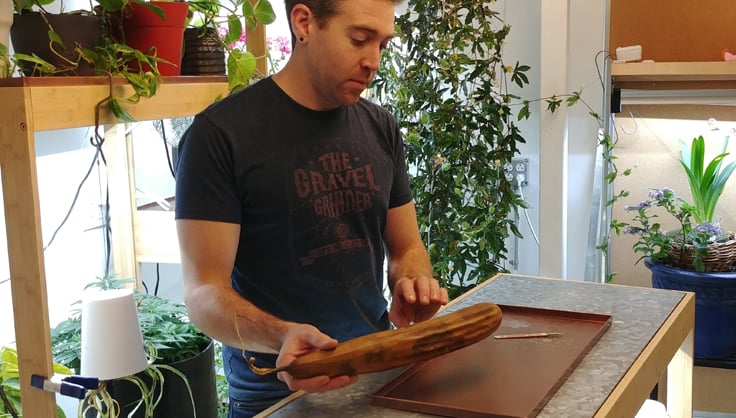 young man holding a tried loofah preparing to peel it